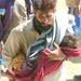A Pakistani Man Carries His Injured Child