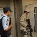 An Iraqi police officer and a Task Force Baghdad soldier search for terrori