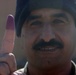 An Iraqi soldiers proudly displays his marked finger after voting