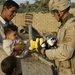 Sgt. Andrew Paasch passes out toys to a small Iraqi child