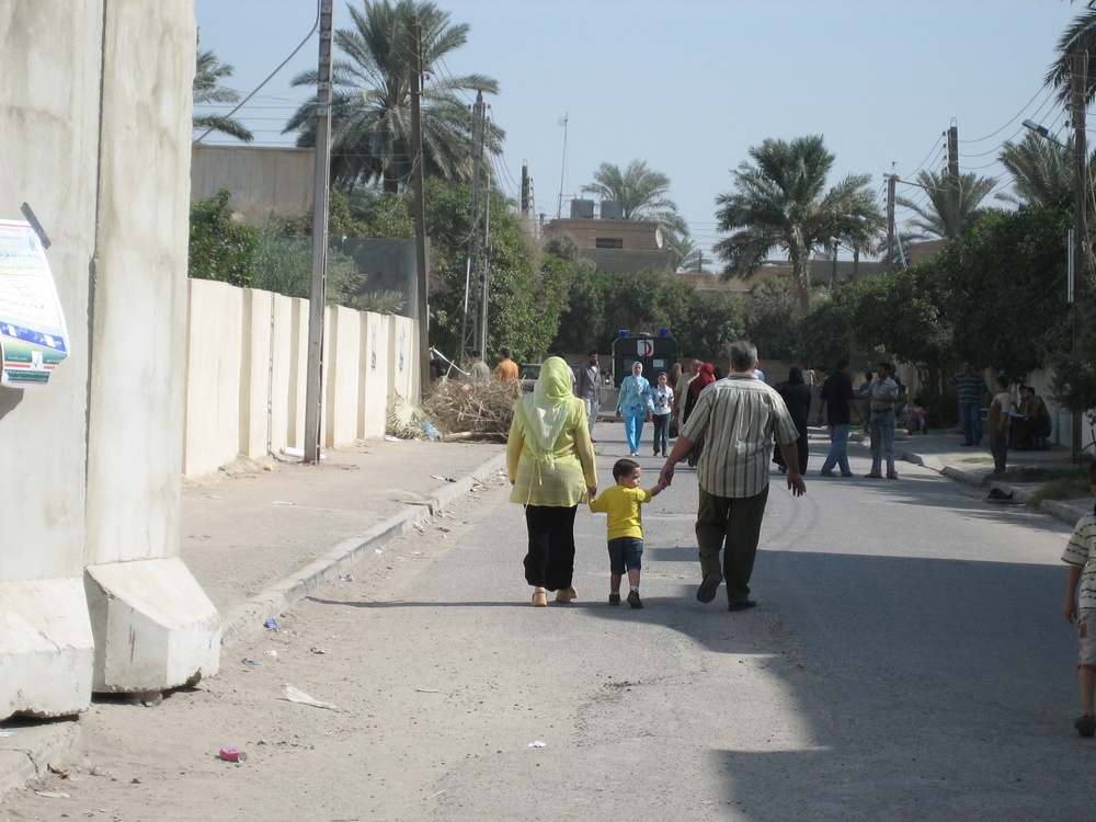 An Iraqi family walks toward a polling site