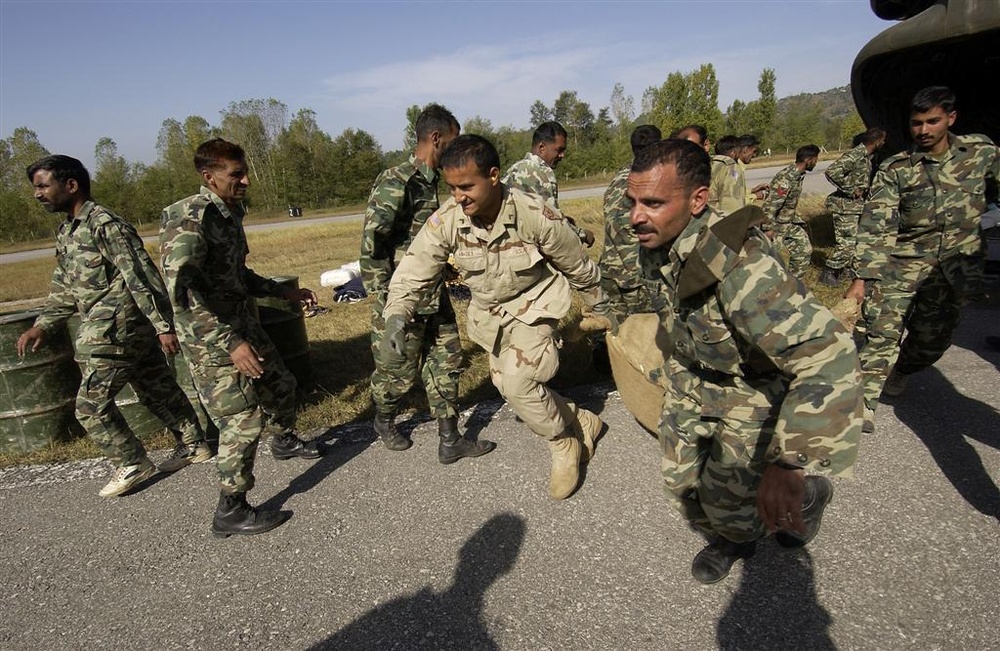 U.S. Army and Pakistani Soldiers rush to unload U.S. medical supplies