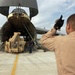 Senior Airman Patterson helps other crewmembers guide a crane onto a C-5 Ga