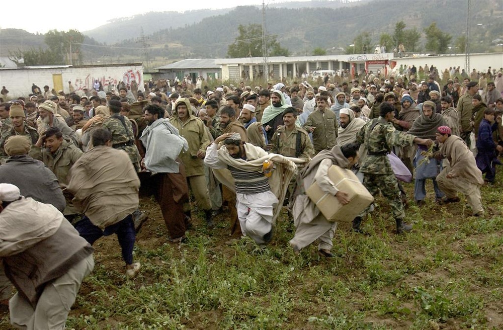 Pakistani soldiers try to control the crowd of local Pakistanis