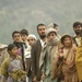 Village residents wait as Pakistani soldiers unload disaster relief supplie