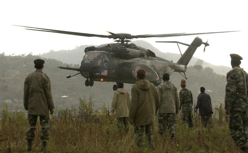 Pakistani soldiers watch as a U.S. Navy MH-53E Sea Dragon helicopter lands