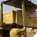 Pakistani relief workers load trucks of humanitarian supplies for ground tr