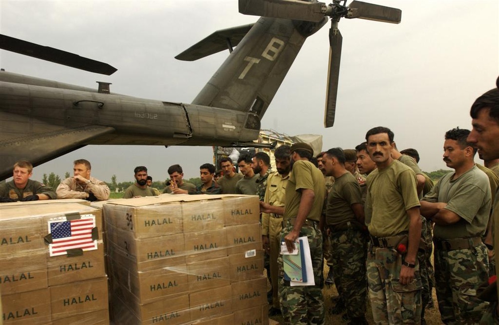 U.S. Navy Sailors and members of the Pakistan military load a MH-53E Sea Dr