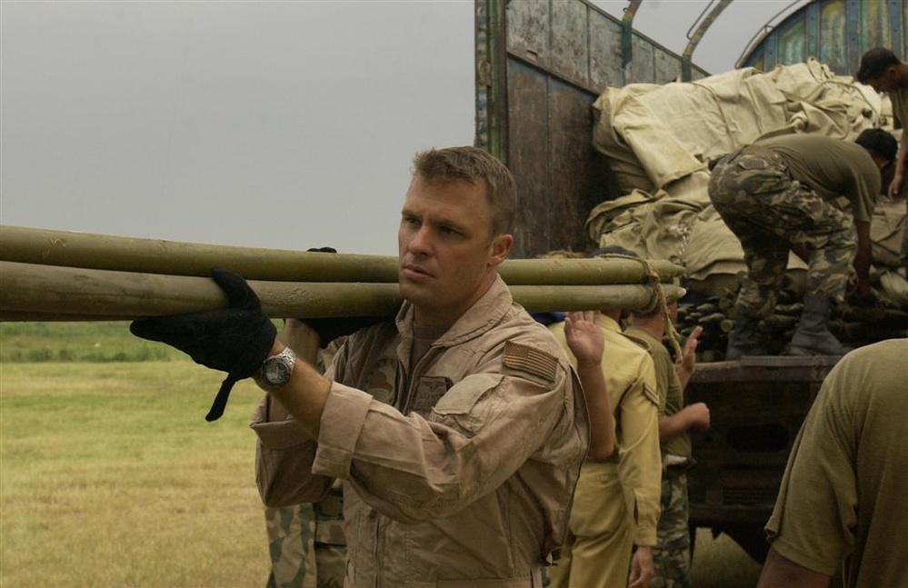 U.S. Navy Sailors and members of the Pakistan military load a MH-53E Sea Dr