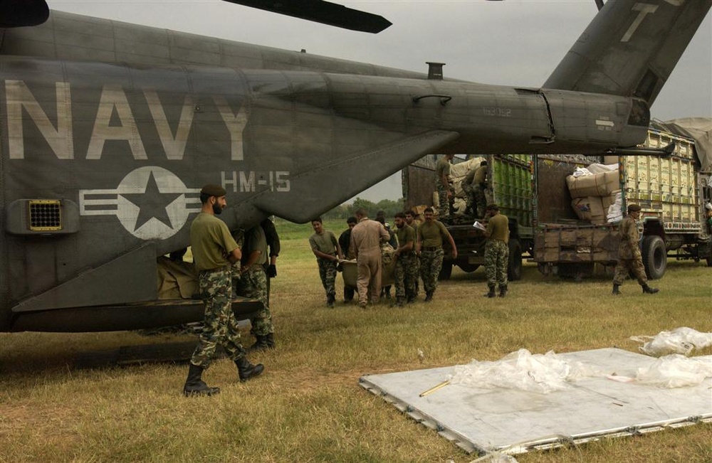 U.S. Navy Sailors and members of the Pakistan military load a MH-53E Sea Dr