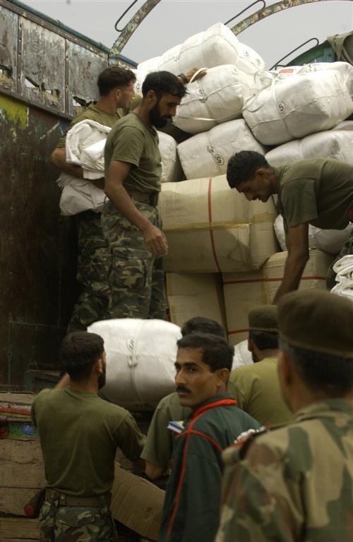 Members of the Pakistan military member load humanitarian supplies on to a