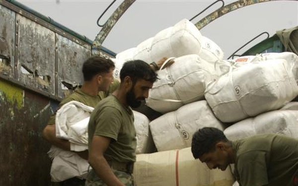Members of the Pakistan military member load humanitarian supplies on to a