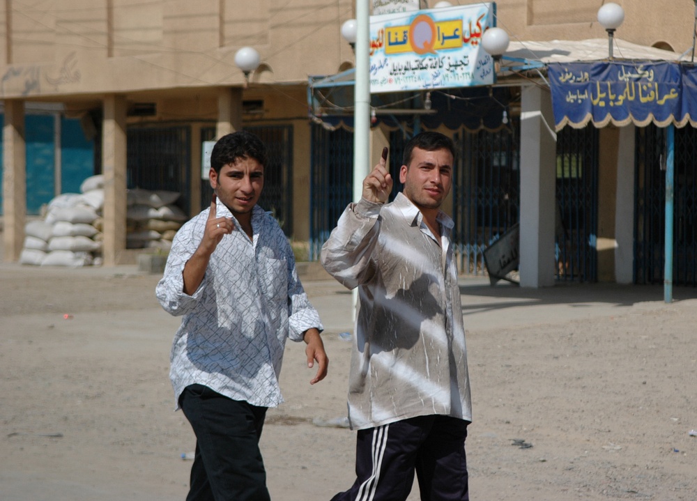 Two Iraqi men leave a polling site