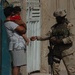 A Soldier shares his MRE with a young Iraqi girl