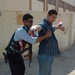 An Iraqi Police officer frisks a local resident