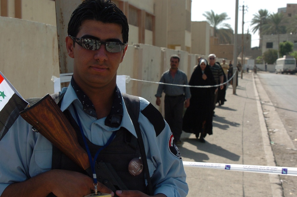 An Iraqi Police officer guards a polling site