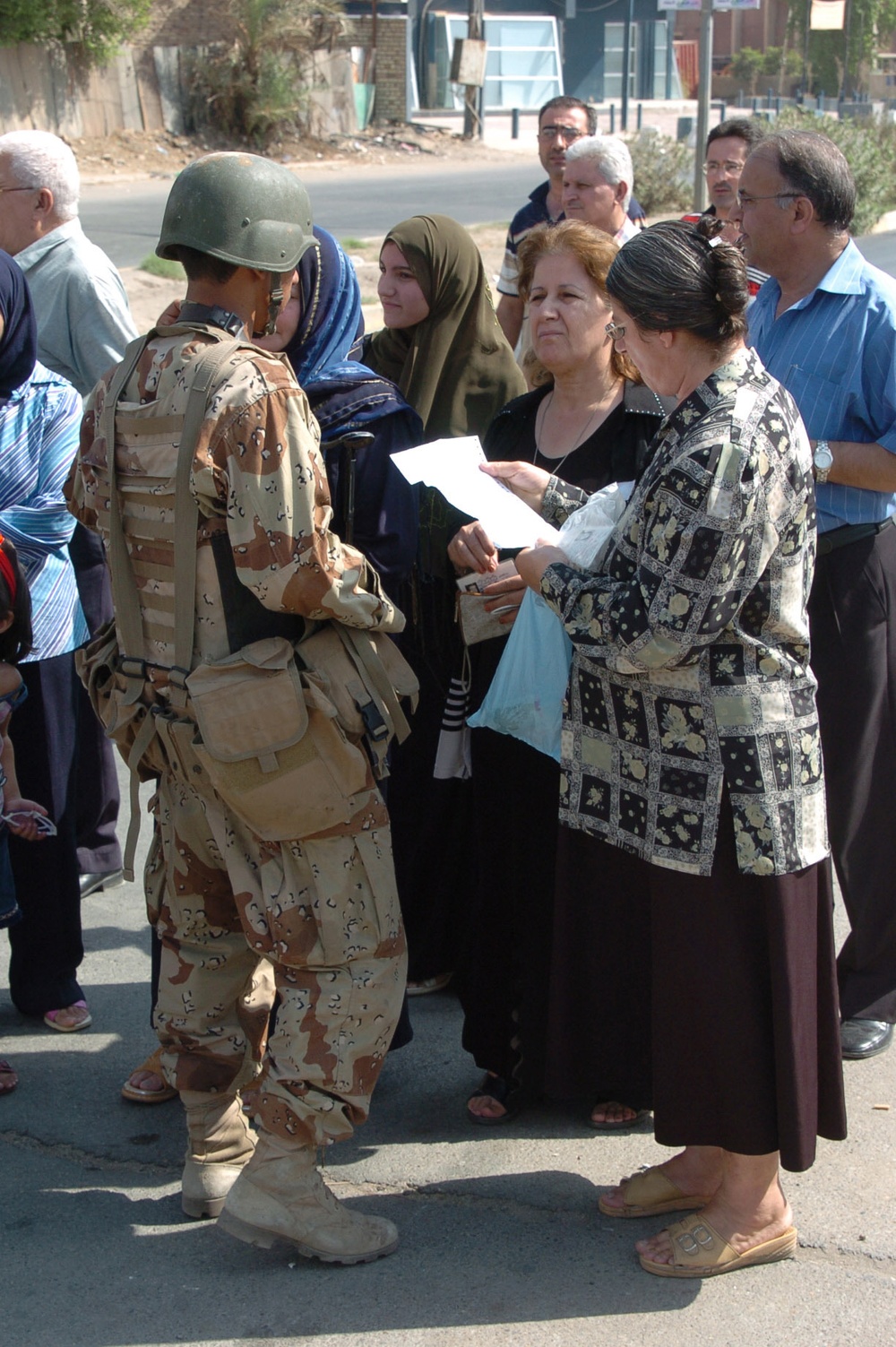 An Iraqi Soldier talks with local residents