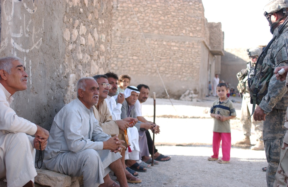 A group of Iraqi men talk to Lt. Col. Gibson