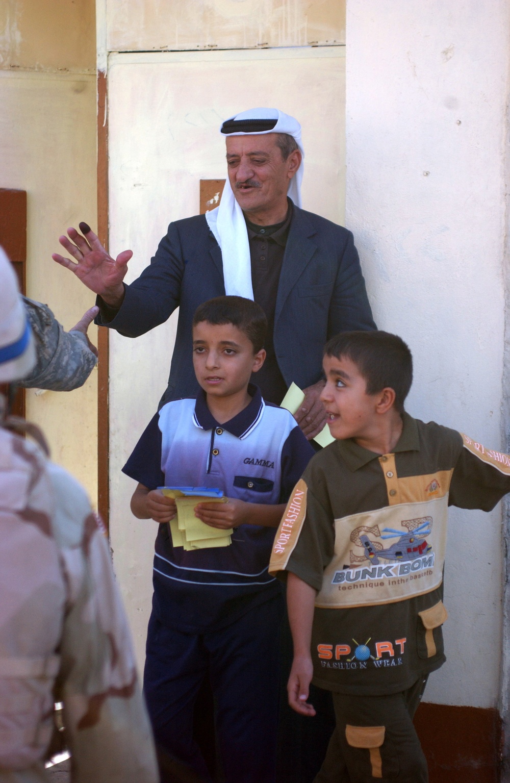 An Iraqi man reaches to shake the hand of a paratrooper