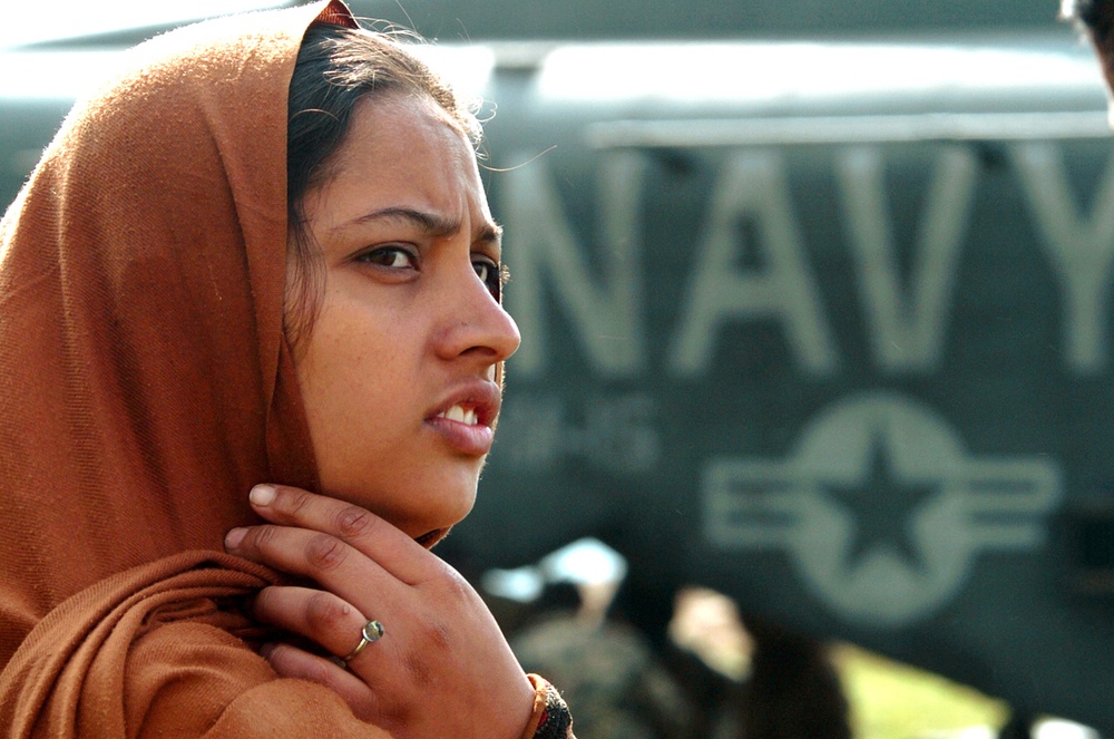 A Pakistani Woman  Watches  as Supplies Are Unloaded From an MH-53 Sea Stal