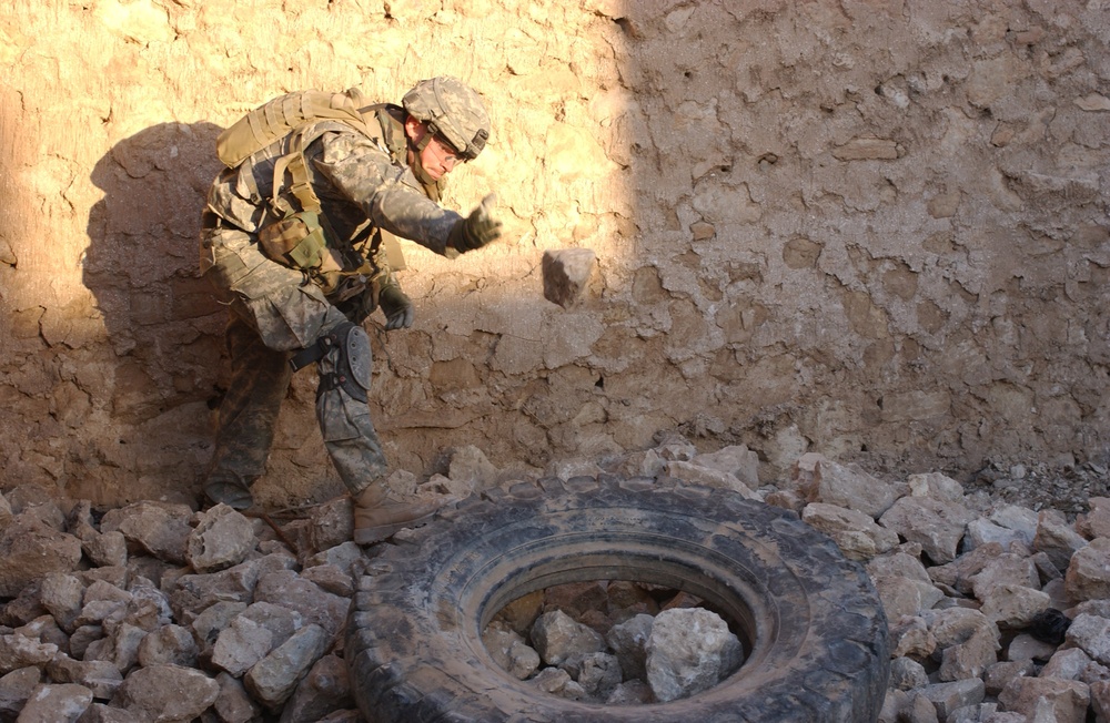 Sgt. Guttersohn throws rocks to the side as he digs