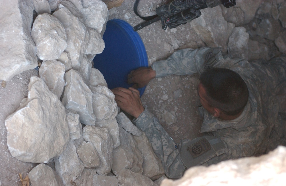 Pfc. Cuellar reaches into a cache buried in the ground