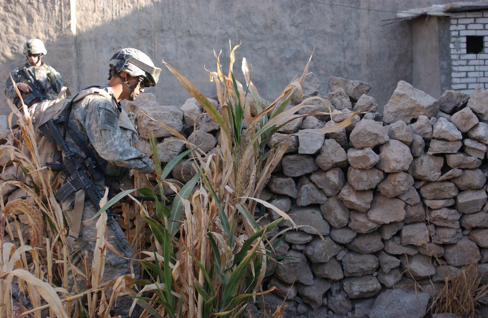 Pfc. Cuellar uses a metal detector to search a wall