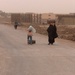 A mother and daughter move two propane tanks down a newly-opened road