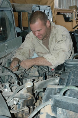 Spc. Scot S. Sheftz Plugs a Generator Into a Humvee