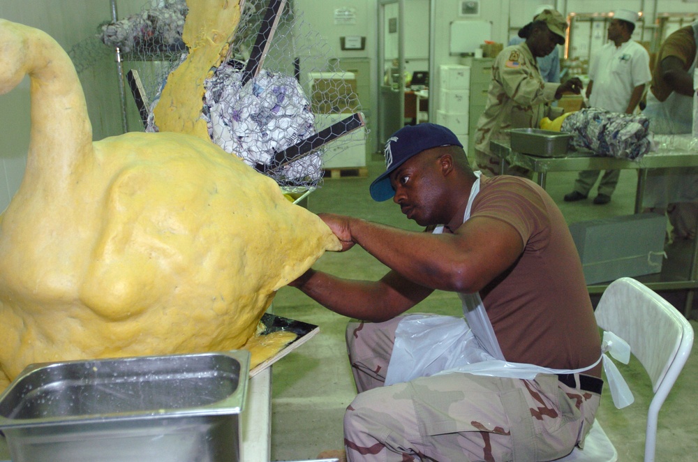 Sgt. 1st Class Slayton Forms Dough Onto the Tail of a Turkey Food Sculpture