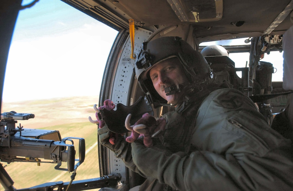 A Helicopter Crew Member Tosses Toys to the Children in the Village Below.