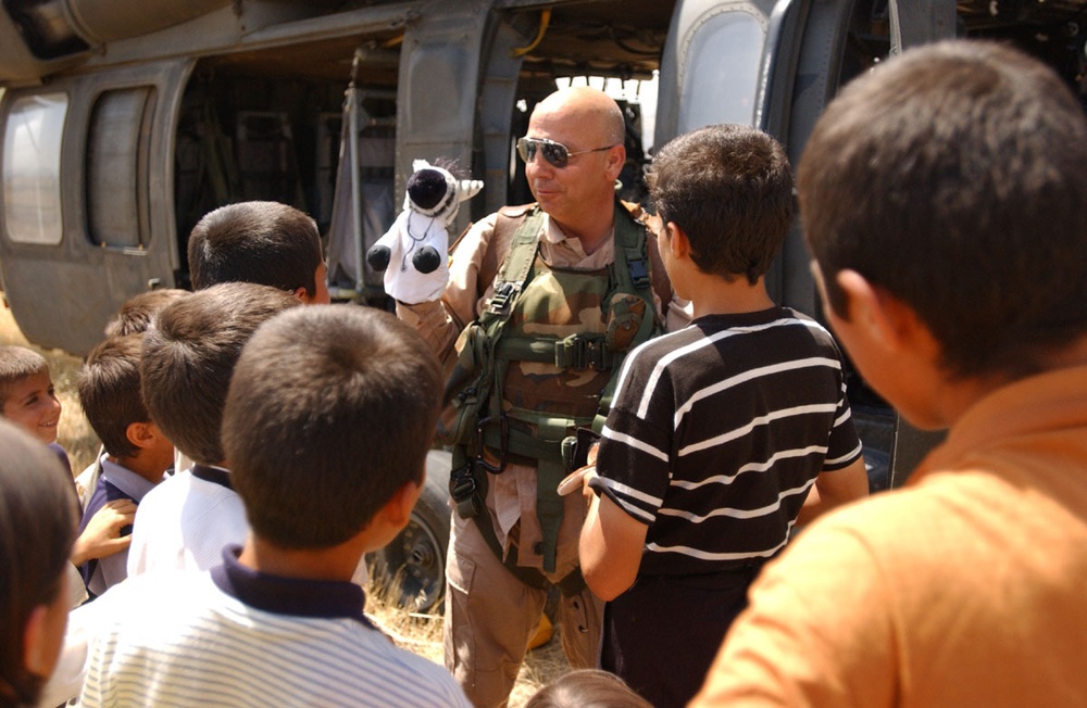 CW3 John Paul King gives a small puppet show for Iraqi children