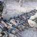 Soldiers prepare a stack of munitions for demolition