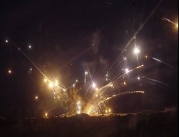 A pile of munitions explodes in flames