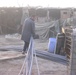 An Abu Ghraib resident helps unload PVC pipes