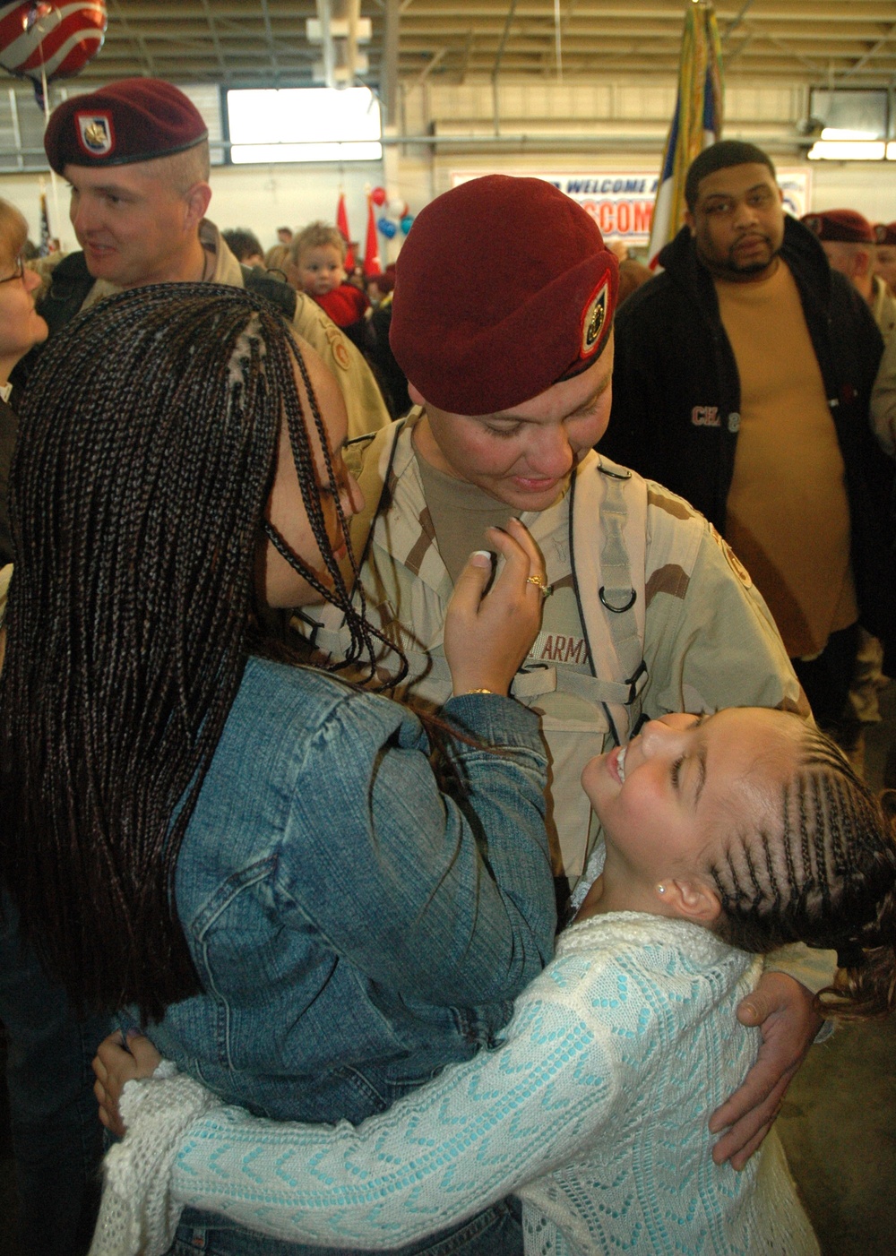 Spc. Mark Reali hugs his wife and daughter