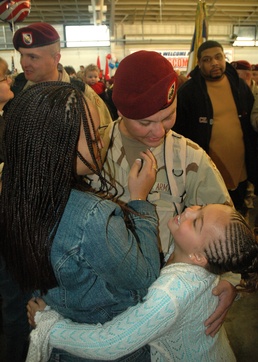 Spc. Mark Reali hugs his wife and daughter