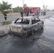 Iraqi firefighters finish putting out a fire after a terrorist rocket attac