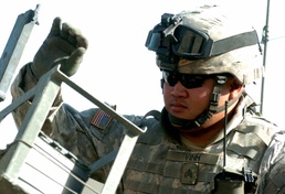 Sgt. Andy B. Vinh loads a .50 caliber machine gun before a patrol
