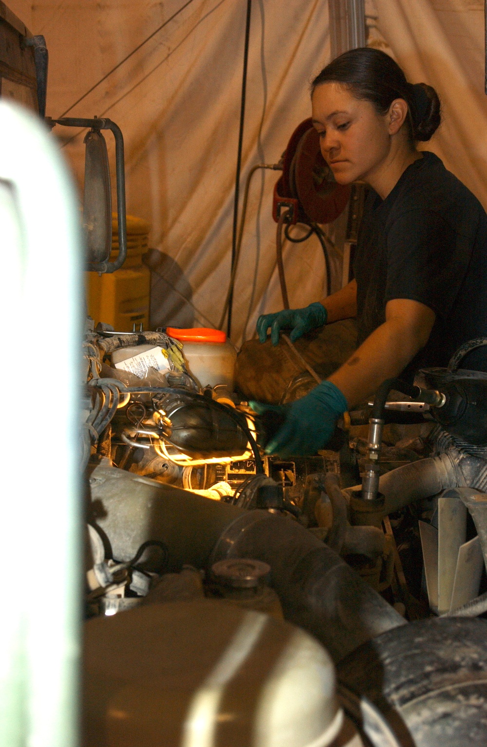 Airman 1st Class Sara Gaines illuminates the area around a fuel filter she