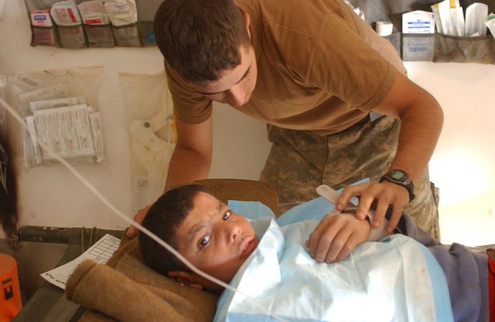 Pfc. Weaver checks a boy's vitals