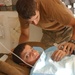 Pfc. Weaver checks a boy's vitals