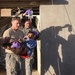 Sgt. Johns carries a young boy who was shot in the foot to a waiting vehicl