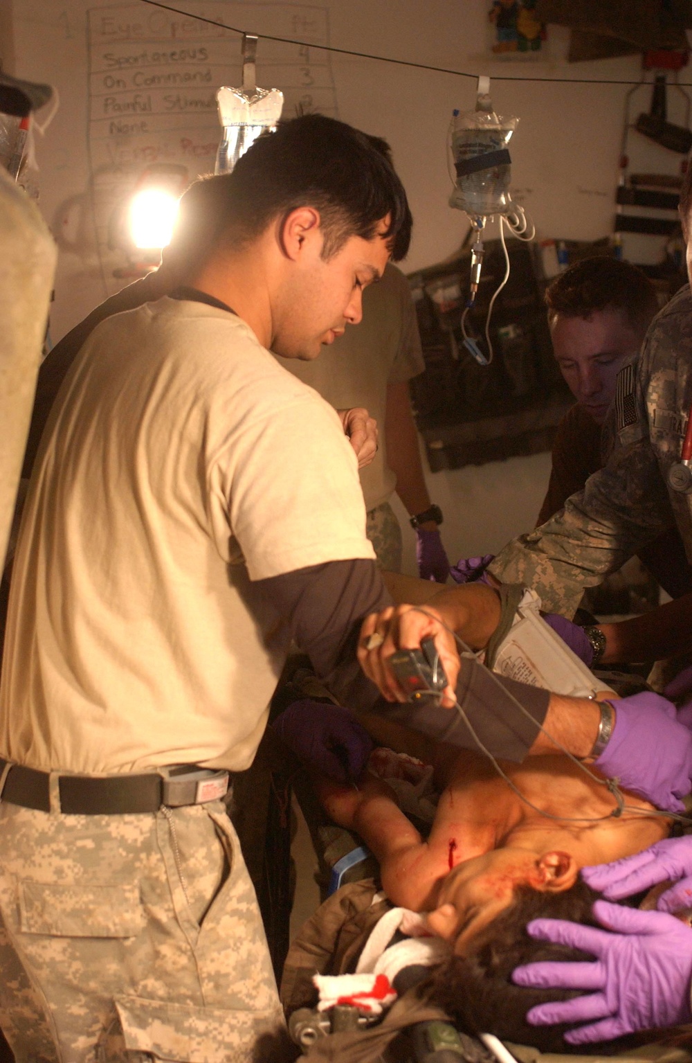 Sgt.  Eraso helps roll a wounded man on to his side