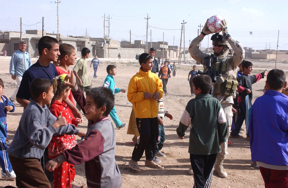 Cpt. Howell Holds a Soccer Ball Over His Head