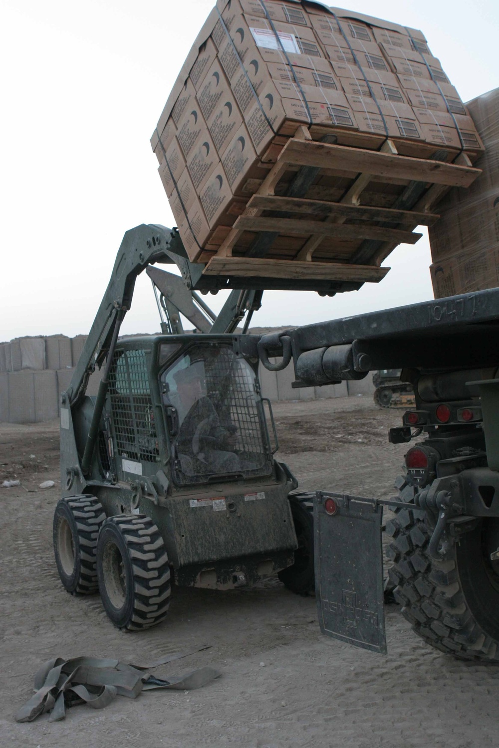 A Soldier operates a fork lift to unload a case of MREs