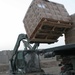 A Soldier operates a fork lift to unload a case of MREs