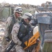 A1C Cruz and Tech. Sgt. Ralls use a K-12 to saw on the hinges of a vehicle