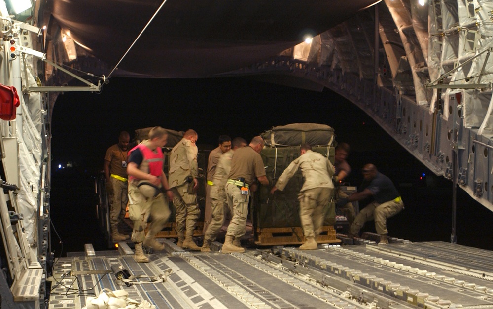 Servicemembers load supplies onto a C-17