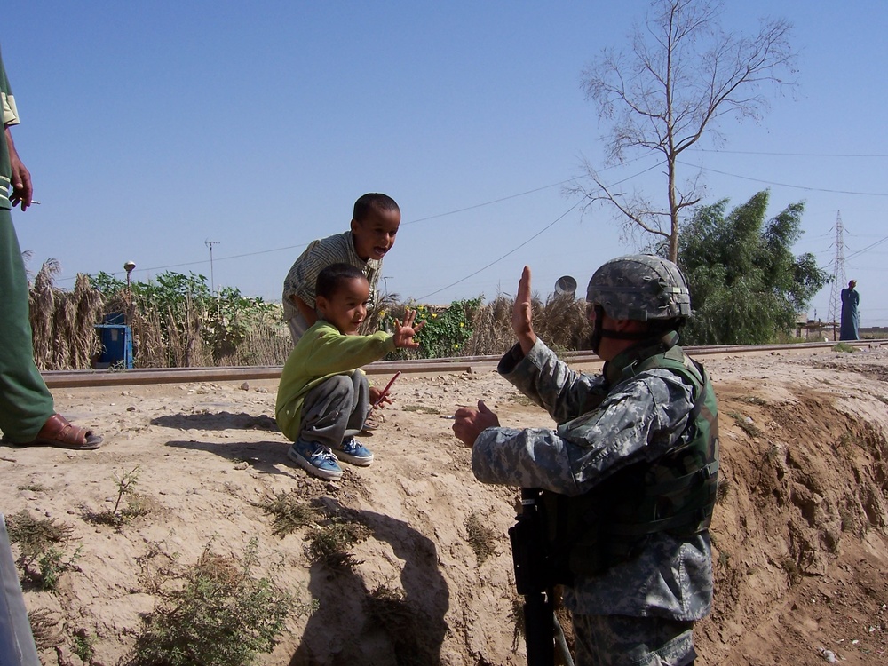 A Soldier &quot;high-fives&quot; a young boy